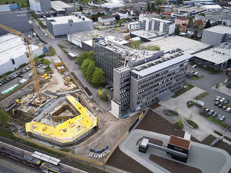 Die Baumaßnahmen für den Schüco One Neubau schreiten gut voran. Die Bodenplatte ist bereits gegossen, die Schalungen für die Außenwände und den inneren Erschließungskern wurden gestellt und lassen bereits auf die spätere Dimension des Gebäudes schließen. Foto: © Schüco International KG