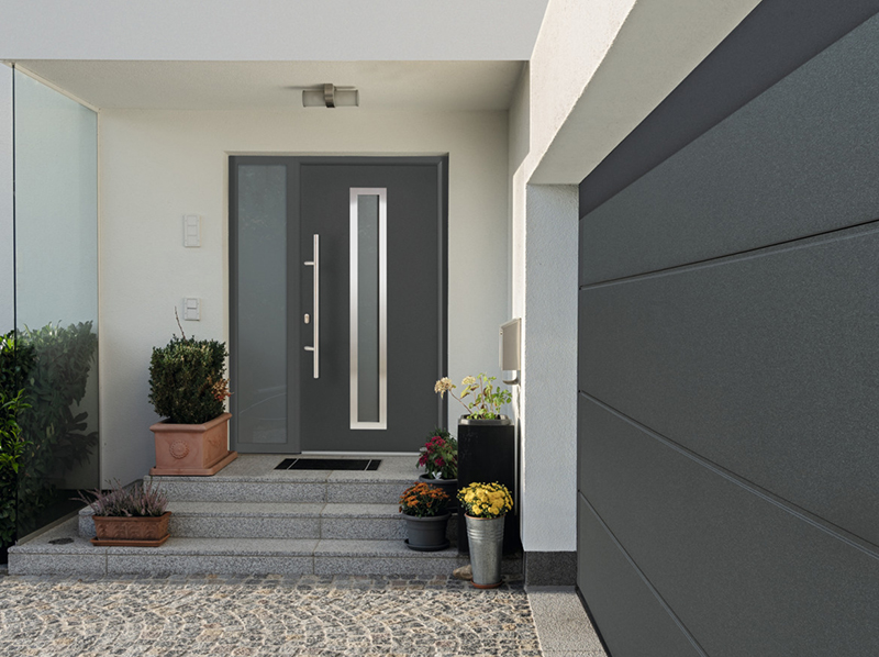 Tor und Tür aufeinander abgestimmt: Das im Rahmen der EuropaPromotion erhältliche Hörmann Garagentor RenoMatic 2019 und auf Wunsch auch die Aluminium-Haustür ThermoSafe sind unter anderem in der neuen glatten Oberfläche Planar erhältlich. Dabei stehen sechs exklusive Hörmann Farbtöne Matt deluxe zur Auswahl. Foto: © Hörmann