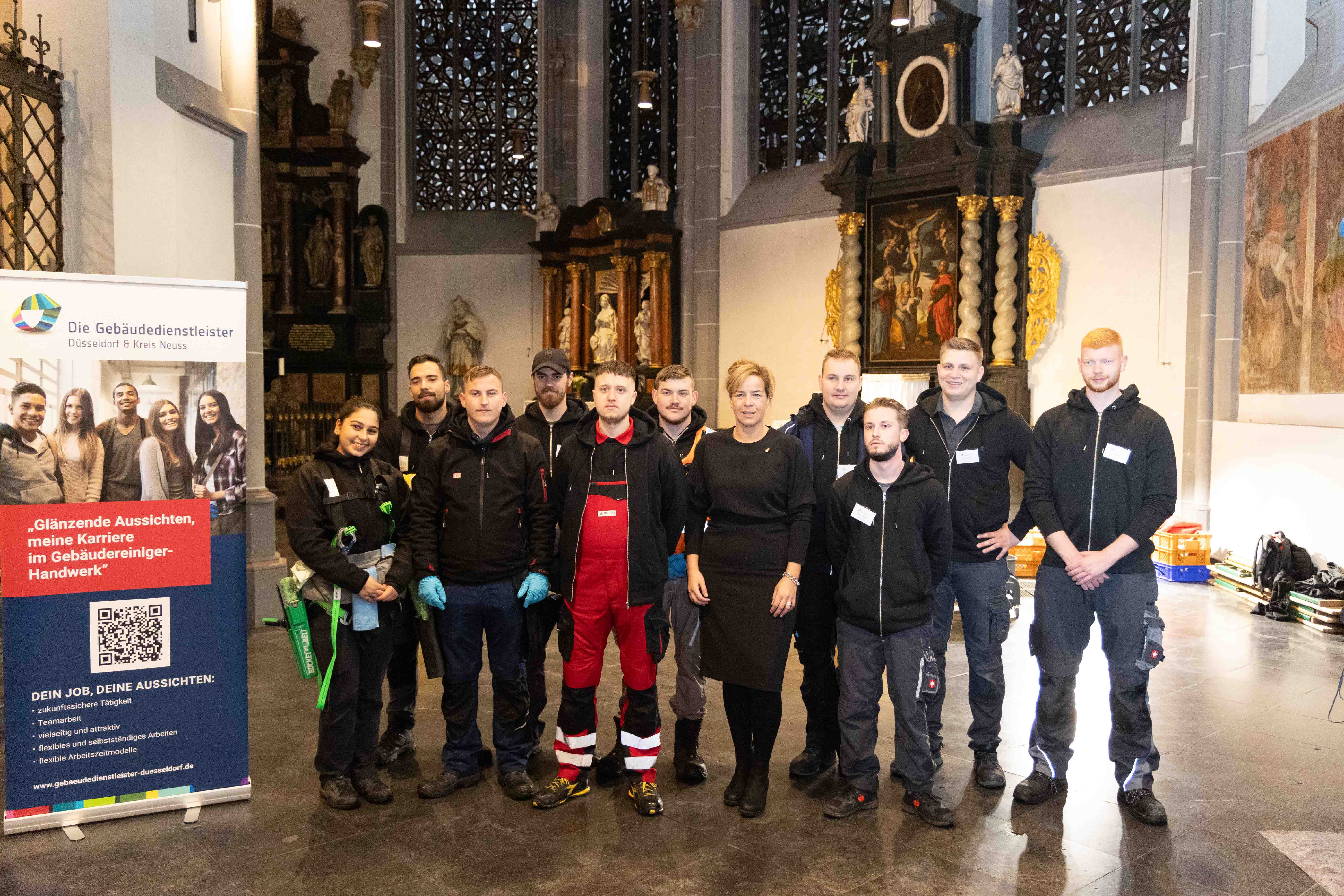 Die nordrhein-westfälische Wirtschaftsministerin Mona Neubaur (5.v.r.) machte sich selbst ein Bild von der Deutschen Meisterschaft der Gebäudereiniger in der Basilika St. Lambertus in Düsseldorf. Foto: © BIV Gebäudereiniger