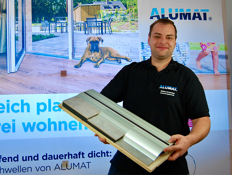 An Neuheiten herrscht kein Mangel, hier zeigt Stefan Anwander aus dem Produktmanagement und Prüfwesen von Alumat die neuen Varianten der stark nachgefragten Sanierungsschwelle MHT, mit der Alumat nun auch im Fachhandel sehr präsent ist. Foto: © Alumat / Book Your Video