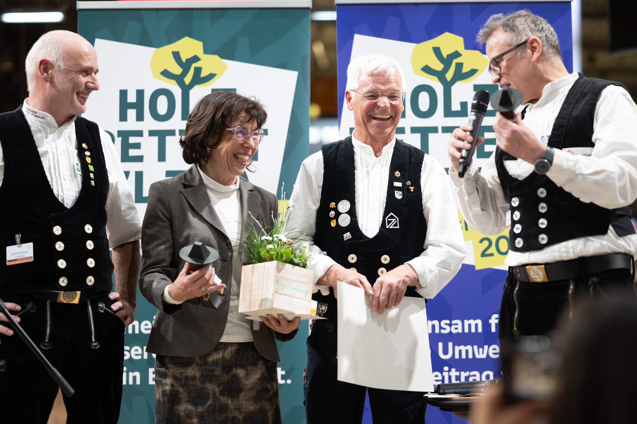 Rolf Rombach (links) und Volker Baumgarten (rechts, beide Vizepräsidenten von Holzbau Deutschland) zeichneten Peter Aichner (2.v.r.) mit der Goldenen Ehrennadel des Zimmererhandwerks aus. Ebenfalls im Bild: Margit Aicher Foto: © Holzbau Deutschland