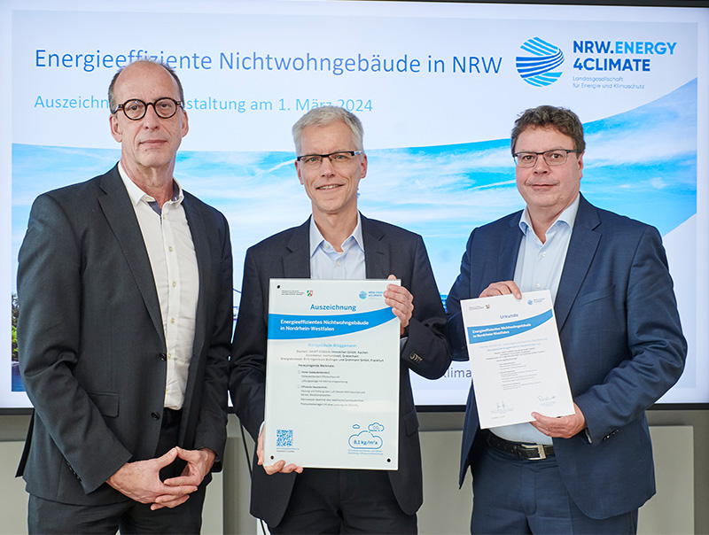 Übergabe der Auszeichnung in Düsseldorf: Michael Theben, Abteilungsleiter Klimaschutz im Ministerium für Wirtschaft, Industrie, Klimaschutz und Energie des Landes Nordrhein-Westfalen, Werner Hansmann, Sprecher der Geschäftsleitung der Saint-Gobain Brüggemann Holzbau GmbH und Carsten Petersdorff, Bereichsleiter Wärme und Gebäude der NRW.Energy4Climate GmbH (von links nach rechts). Foto: © Björn Hickmann NRW.Energy4Climate
