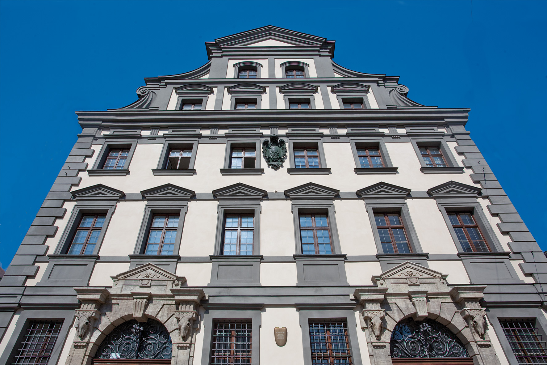 Auch eine Verkaufshalle der Augsburger Metzger zählt zu den 22 Objekten des Unesco-Welterbes Augsburger Wassermanagement-System. An der Fassade sieht man deshalb steinerne Rinderschädel. Was man nicht sieht: Unter dem Renaissancebau verläuft ein eiskalter Lechkanal, der hier ab 1609 die Fleischbänke kühlte. Foto: © Martin Kluger