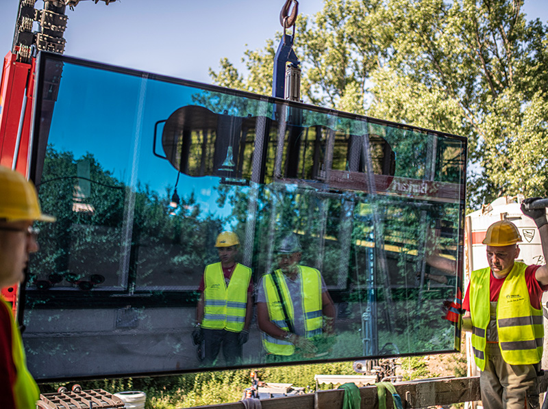 Im Juni startete die spektakuläre Montage der ersten Scheiben, die mit einer Größe von 1,3 x 3 Metern immerhin 370 kg auf die Waage bringen. Foto: © Freyler Metallbau