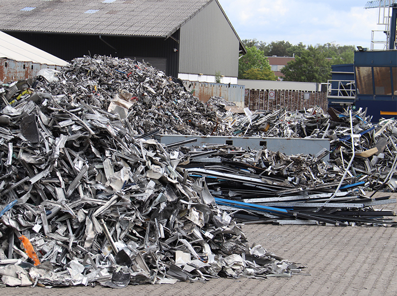 Die rückgeführten Aluminiumprofile aus Fenstern, Türen und Fassaden werden in einem Recyclingprozess aufbereitet. Aus dem sortenreinen Aluminium werden dann erneut Pressbolzen und später hochwertige Profile für Bauelemente hergestellt. Foto: © Vössing