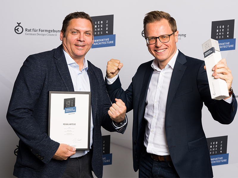 Die Freude über die renommierte Auszeichnung ist groß. Peter Kotzur, Director Marketing Rehau Window Solutions (rechts), und Sven Piller, Produktmanager Rehau Window Solutions, präsentieren Pokal und Urkunde des Iconic Awards 2024. Foto: © Rat für Formgebung / Jens Hartmann