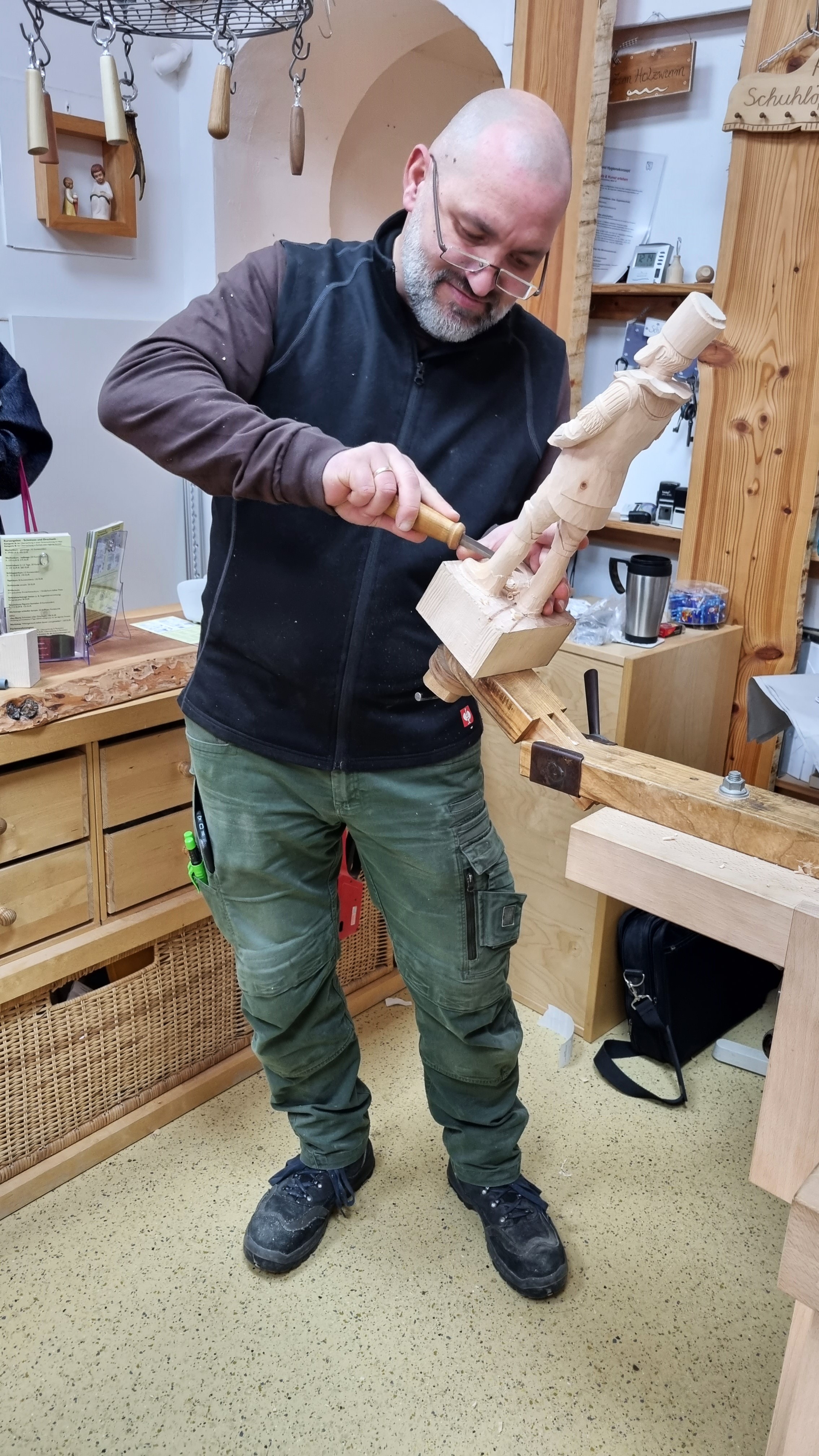 Lars Neubert in seinem Atelier beim Schnitzen eines Bergmanns. Foto: © Cornelia Ganitta