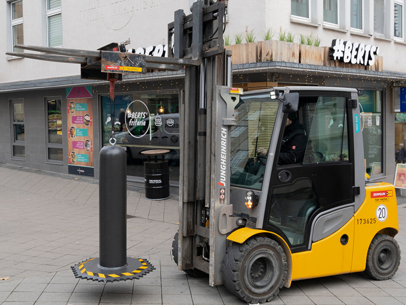 Mithilfe einer einschraubbaren Transporthilfe im Pollerdeckel kann die mobile Fahrzeugsperre OktaBlock von Hörmann mit einem Kran oder Stapler einfach platziert werden und ohne technisches Spezialwissen auf- und abgestellt werden. Foto: © Hörmann