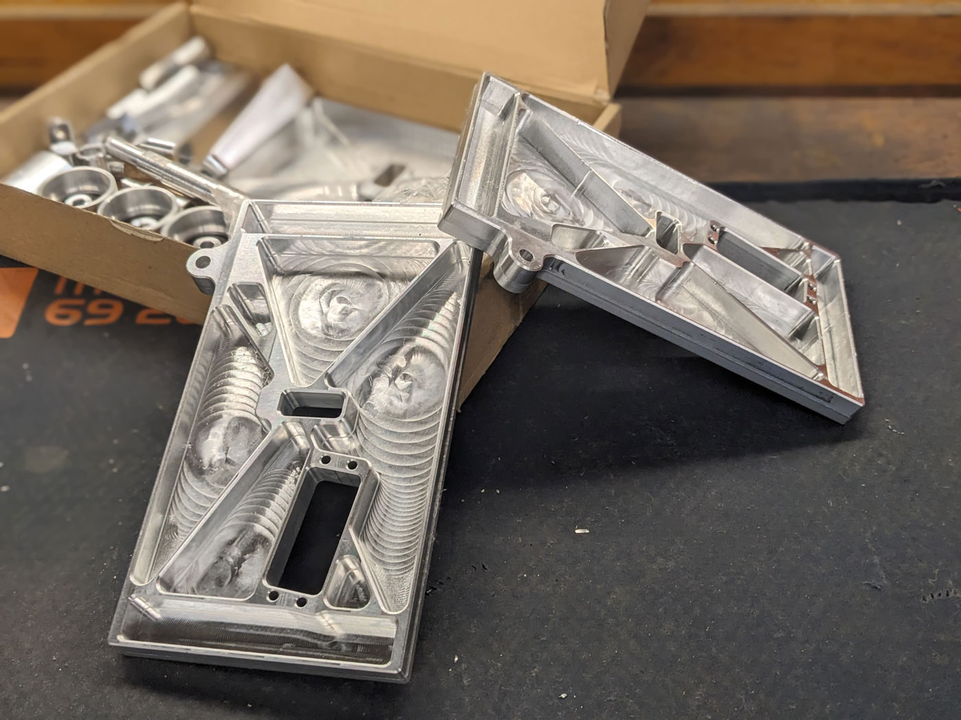 CNC-milled components, with the side plates on which the carbon tube frame is attached in the foreground. The wheel axle is guided through the central elongated hole. Photo: © WARR