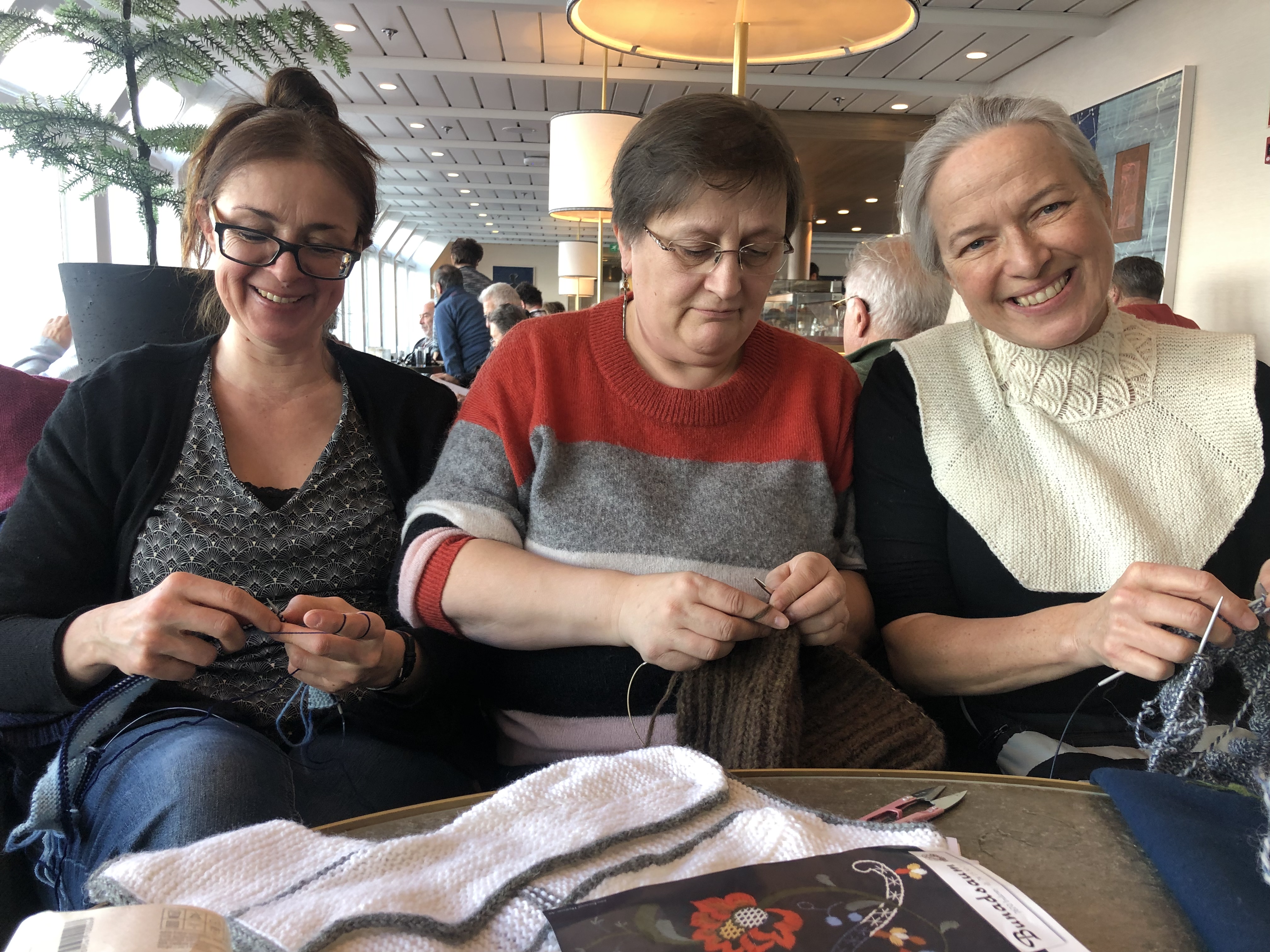 Paticia Becker (l.) kommt aus Frankfurt. Die Museumspädagogin hat sich dem Stickcluborges Husflidslag mit der Vorsitzenden Karoline Lohrengel (r.) und Raumausstatterin Guri-Mette angeschlossen. Die Mitglieder des Strickclubs sind mit der MS Nordnorge auf dem Weg zu den Lofoten. Foto: © DHB