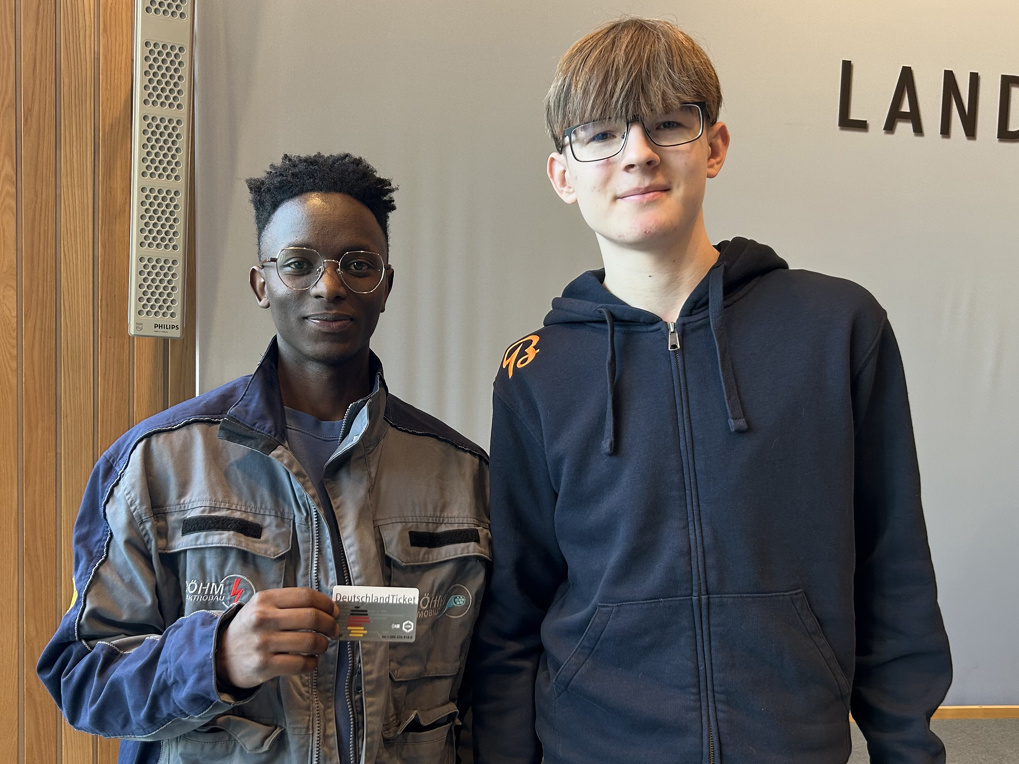 Kelvin Nganga, Auszubildender bei B&ouml;hm Elektrobau (l.), und Noel Schwedhelm, Auszubildender bei der Breilmann AG, freuen sich &uuml;ber das Deutschlandticket. Foto: © Kirsten Freund