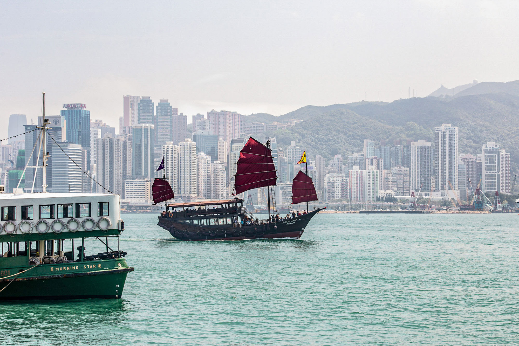 Wie aus der Zeit gefallen: eine d&uuml;mpelnde&shy; &shy;Dschunke vor der Hongkonger Skyline.   Foto: © Susanne Baade für Hapag-Lloyd Cruises