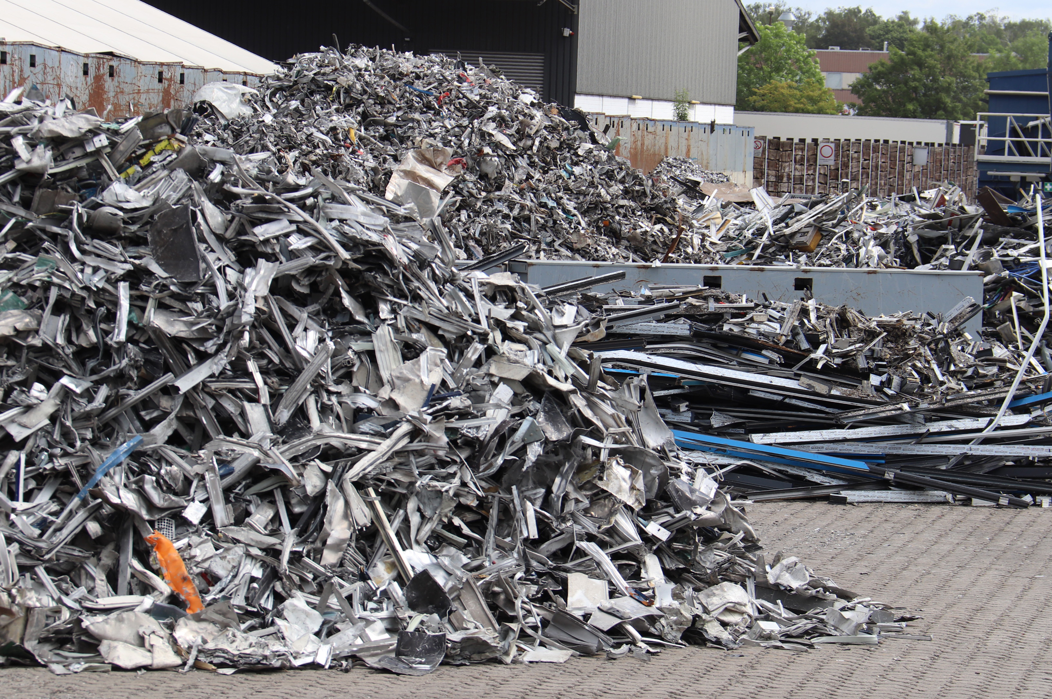 Zertifizierte Recyclingunternehmen bereiten die von der AIUIF Initiative gesammelten Aluminiumschrotte auf und f&uuml;hren das sortenreine Material den Aluminiumh&uuml;tten zu, die da&shy;raus erneut Pressbolzen f&uuml;r die Fertigung neuer Profile f&uuml;r Fenster, T&uuml;ren und Fassaden herstellen. Foto: © Vössing