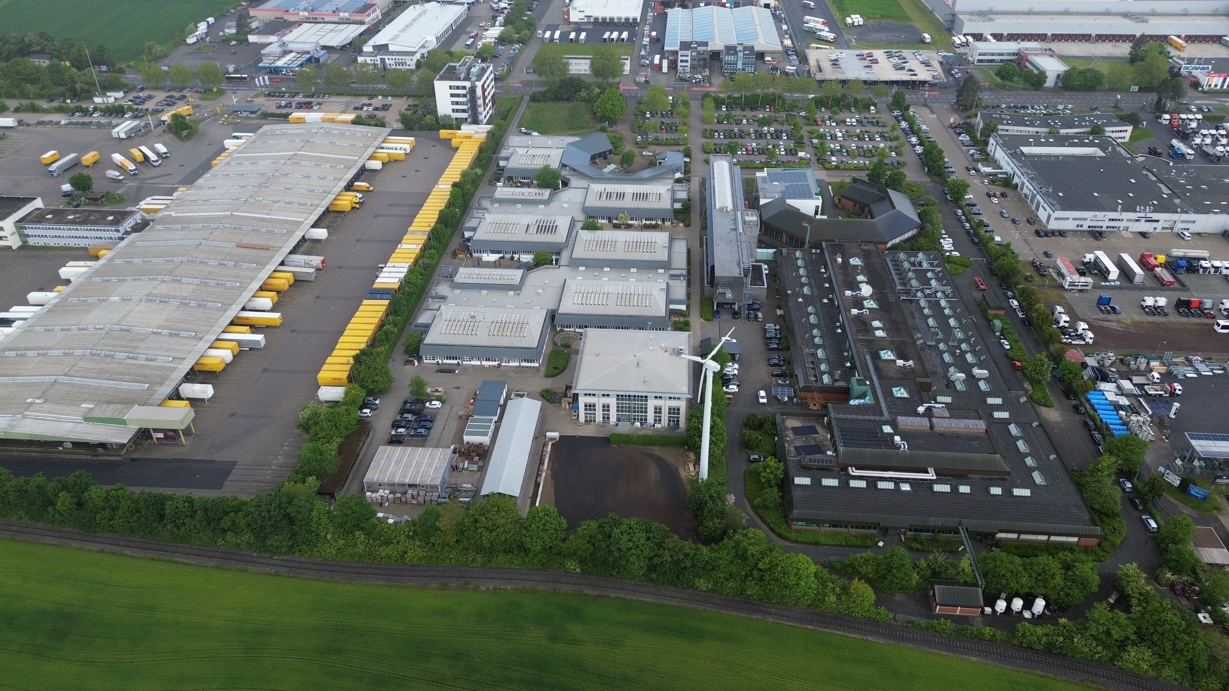Die Berufsbildungszentren der HwK Koblenz in der August-Horch-Stra&szlig;e 6-8 auf einer Fl&auml;che von rund 60.000 Quadratmetern am HwK-Hauptstandort (Geb&auml;udekomplex im Bild Mitte und rechts) sind voll ausgelastet. Deshalb hat die HwK Koblenz seit L&auml;ngerem die B&uuml;ndelung der betriebswirtschaftlichen und rechtlichen Beratungsleistungen sowie der Kammerverwaltung auf einem gro&szlig;en Campus Handwerk geplant. Nun hat sie das Grundst&uuml;ck erworben, das (im Bild links) an das bisherige HwK-Grundst&uuml;ck angrenzt. Das DPD-Verwaltungsgeb&auml;ude (in Richtung August-Horch-Stra&szlig;e) wird k&uuml;nftig als Kammerzentrale genutzt. Foto: © HwK Koblenz/Florian Wagner