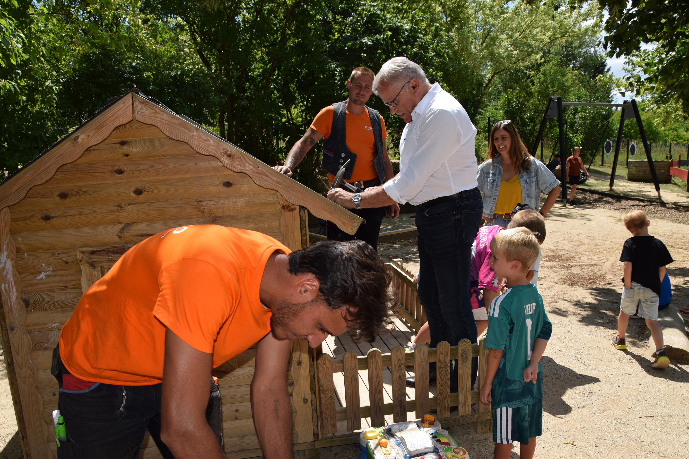 Wenn er schon mal vor Ort ist, l&auml;sst sich HwK-Pr&auml;sident und Dachdeckermeister Kurt Krautscheid (wei&szlig;es Hemd) nat&uuml;rlich nicht lang bitten: Mit viel Spa&szlig; reparierte er unterst&uuml;tzt von den Vorschulkindern sowie Denis Szymik und Fazel Khanan vom Dachdeckerfachbetrieb Salvatore Mannino das Dach des Kita-Spielhauses. Foto: © HwK Koblenz/Dagmar Schweickert