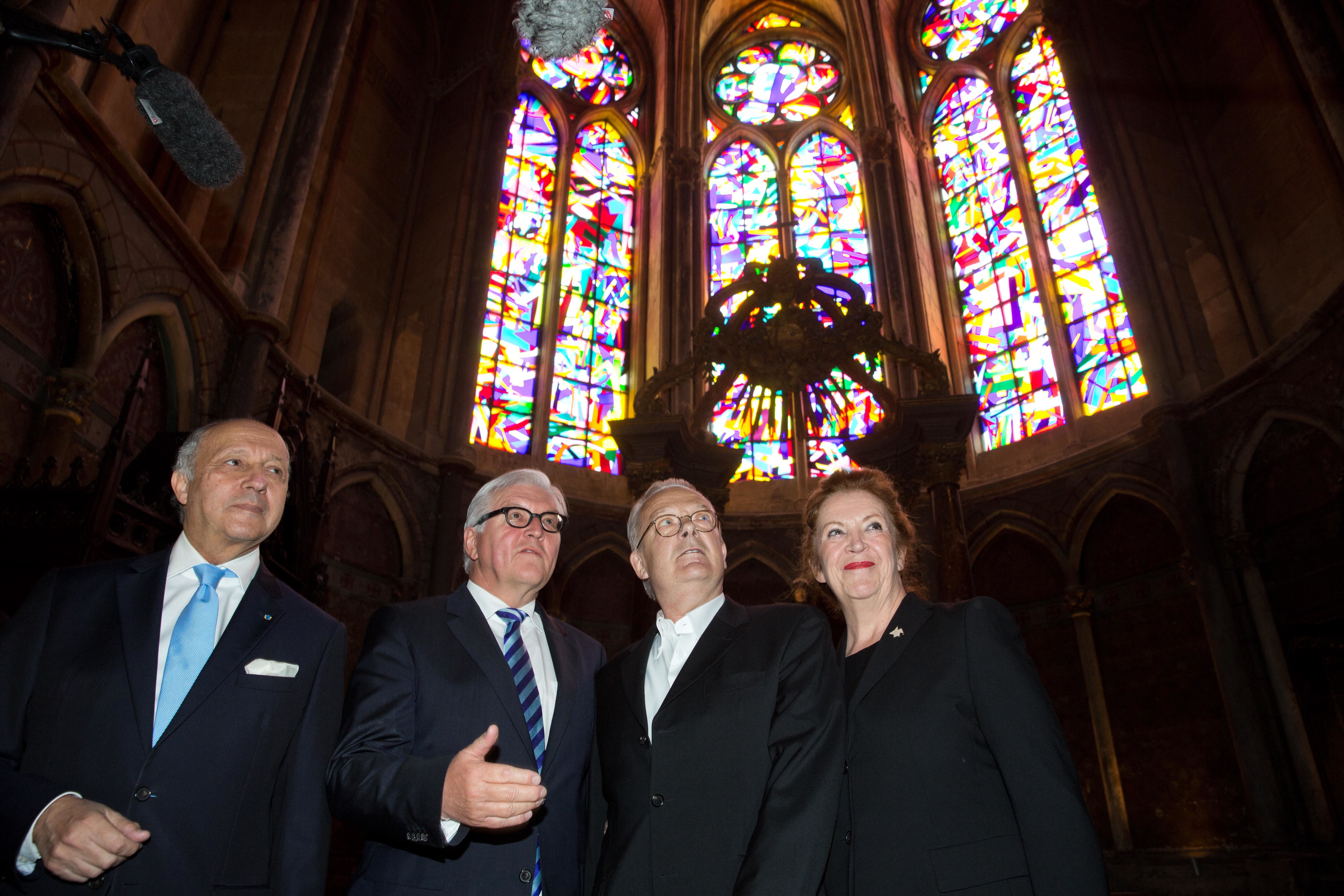 Der damalige französische Außenminister Laurent Fabius (l-r), der damalige Außenminister Frank-Walter Steinmeier (SPD), der Künstler Imi Knoebel und seine Ehefrau Carmen betrachten im Mai 2015 in der Kathedrale drei von Imi Knoebel gestalteten Kirchenfenstern. Foto: © Jörg Carstensen/dpa