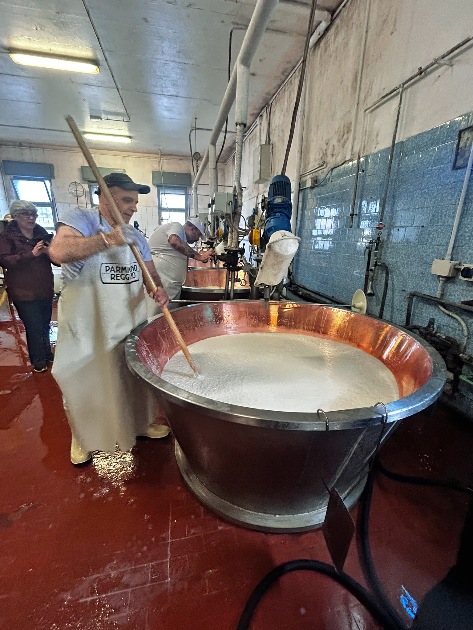 Die Herstellung erfordert viel Muskelkraft. Unter st&auml;ndigem R&uuml;hren erhitzt der K&auml;semeister mit der sogenannten K&auml;seharfe die geronnene Milch. Foto: © DHB