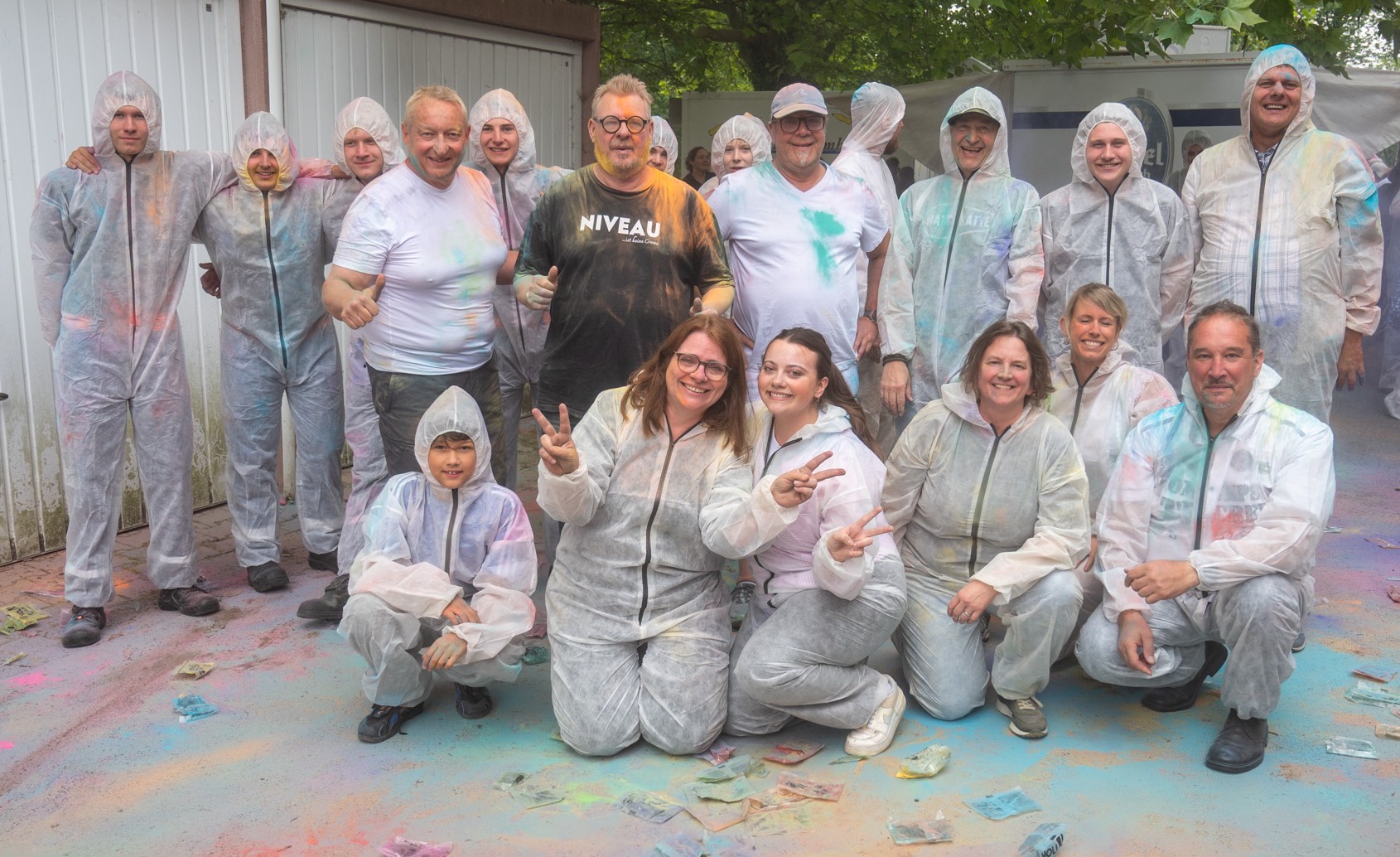 Gemeinsam geschafft: Die frischgebackenen Gesellinnen und Gesellen feiern mit Obermeister Willi Reitz (Mitte) ihren erfolgreichen Ausbildungsabschluss beim ersten Holi-Festival der Maler- und Lackiererinnung Bergisches Land. Foto: © Kreishandwerkerschaft Bergisches Land/Felix Leng