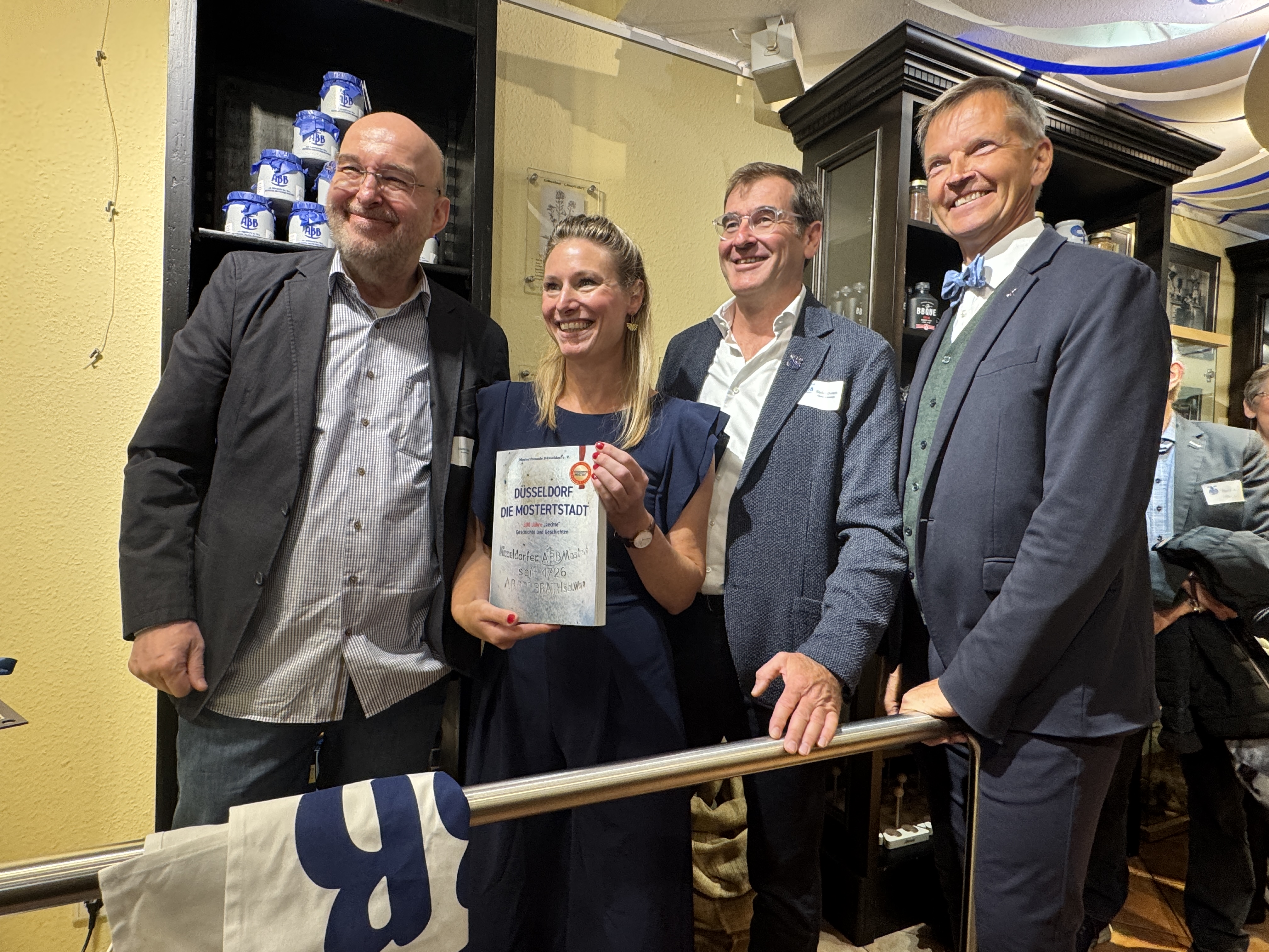 Von links nach rechts: Dieter T&ouml;pfer vom Verein Mostertfreunde D&uuml;sseldorf, Yvonne Uhr vom Senfladen D&uuml;sseldorf, Develey-Gesch&auml;ftsf&uuml;hrer Stefan Durach und B&uuml;rgermeister Josef Hinkel bei der Pr&auml;sentation des neuen Buches 'D&uuml;sseldorf &ndash; die Mostertstadt'. Foto: © Verena S. Ulbrich/DHB