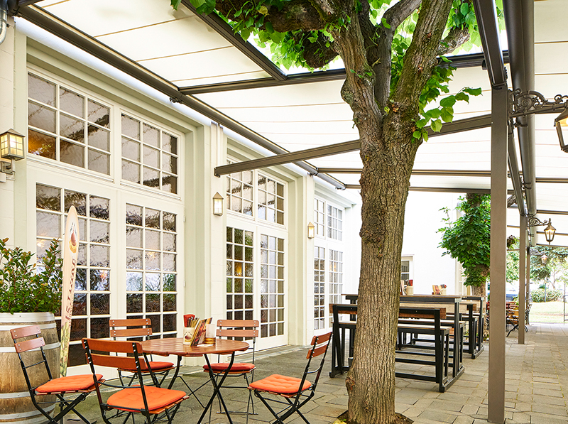 Einige alte Kastanienbäume auf der Terrasse wurden geschickt in das neue Sonnenschutzkonzept integriert. Foto: © Markilux