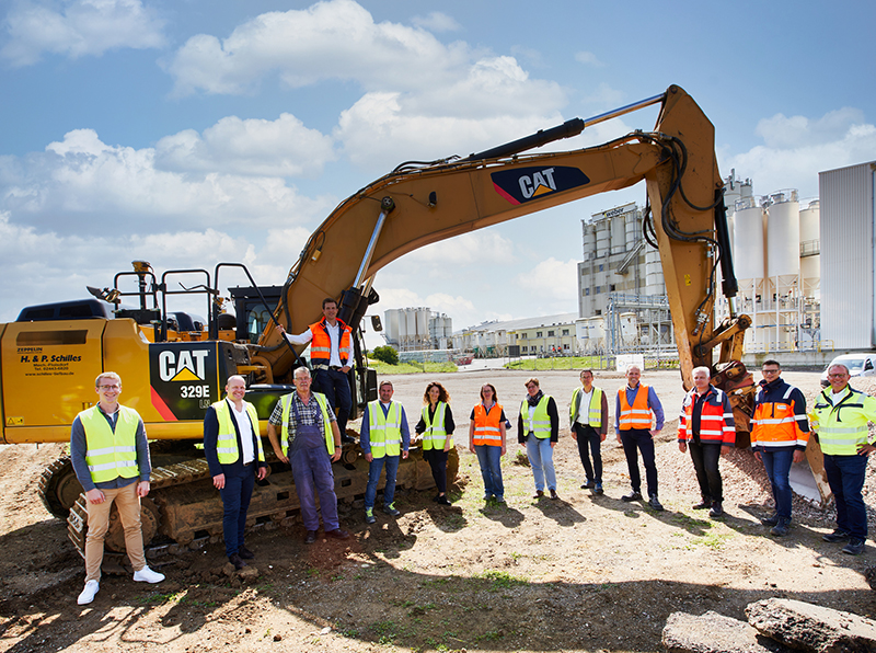 Wo heute noch Brachfläche ist, wird ab Sommer 2022 lebhaft produziert und verladen. Im Bild das Weber Projektteam mit Vertretern der beteiligten Baufirmen Bührer und Wehling Projekt GmbH, Oberhausen (links), sowie OAS AG, Bremen (rechts). Foto: © Saint-Gobain Weber