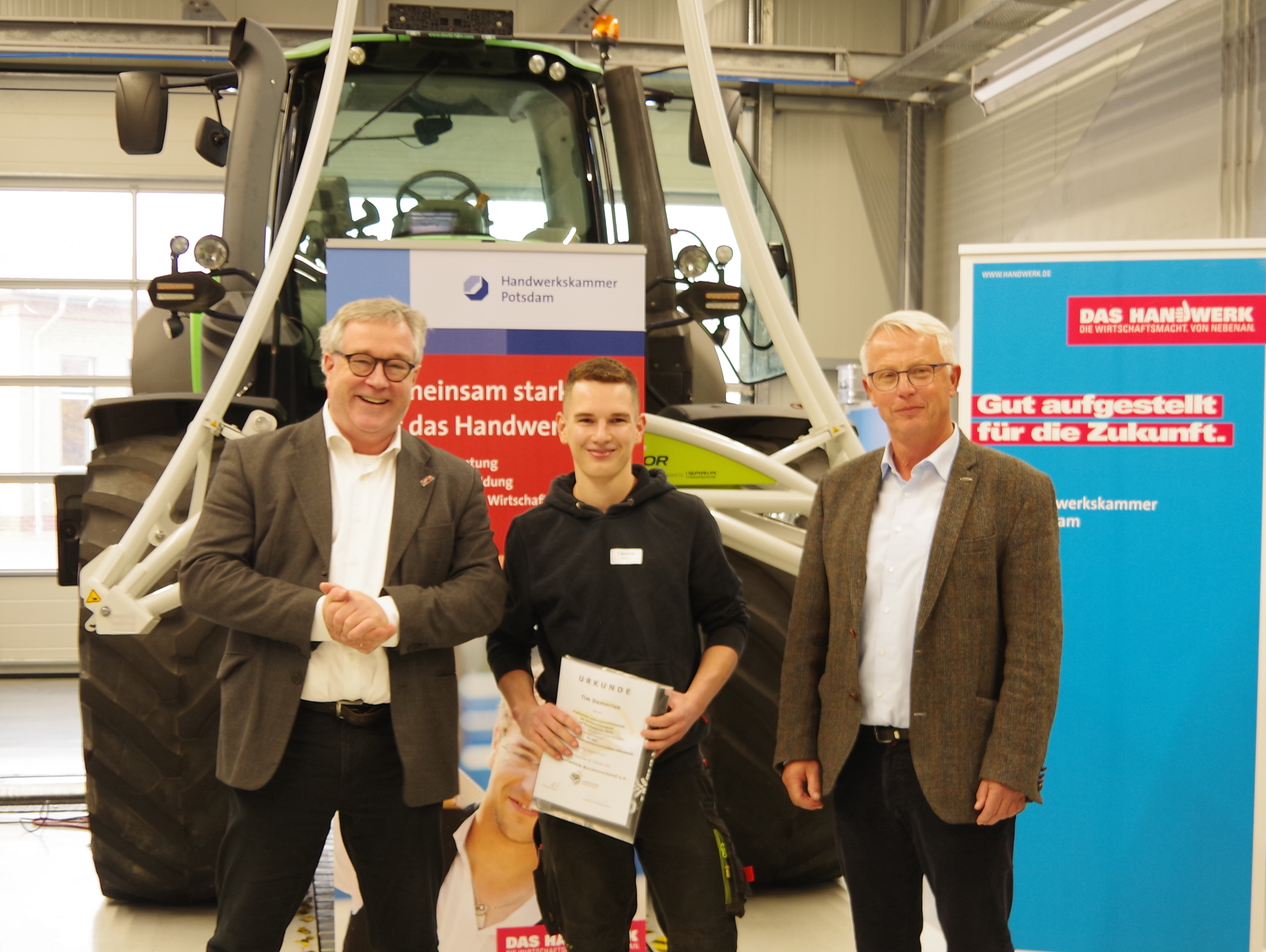 Tim Damerius (M.) ist Deutscher Meister der Land- und Baumaschinen-Mechatroniker 2021. Dem Sieger des Bundesleistungswettbewerbs PLW gratulierten Ulrich Beckschulte (l.) vom LandBauTechnik Bundesverband und Eckhard Vlach, Vorstandsmitglied der Handwerkskammer Potsdam. Foto: © LandBauTechnik Bundesverband