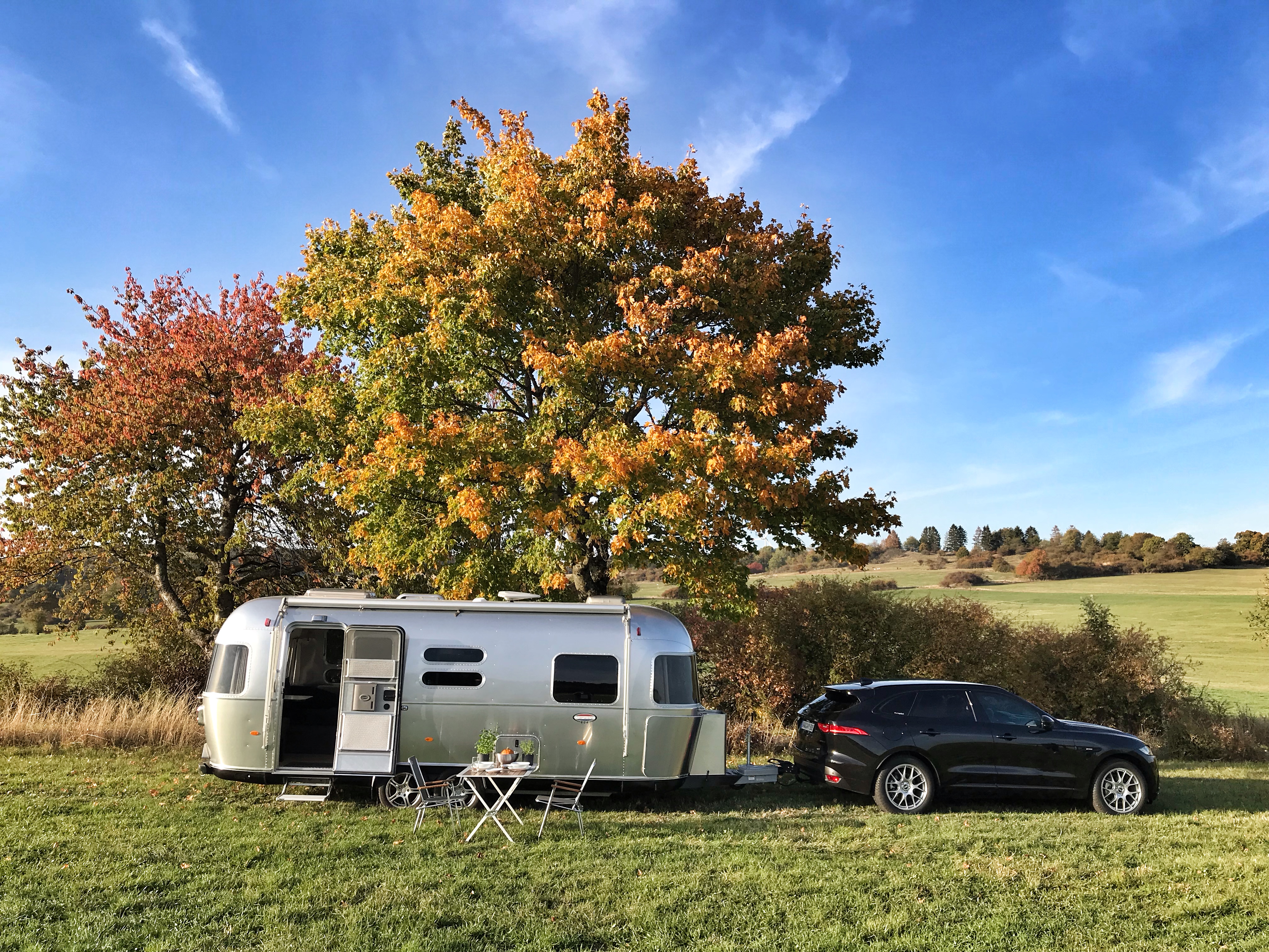 Der glänzende Wohnanhänger strahlt in der Sonne. Foto: © Airstream Germany