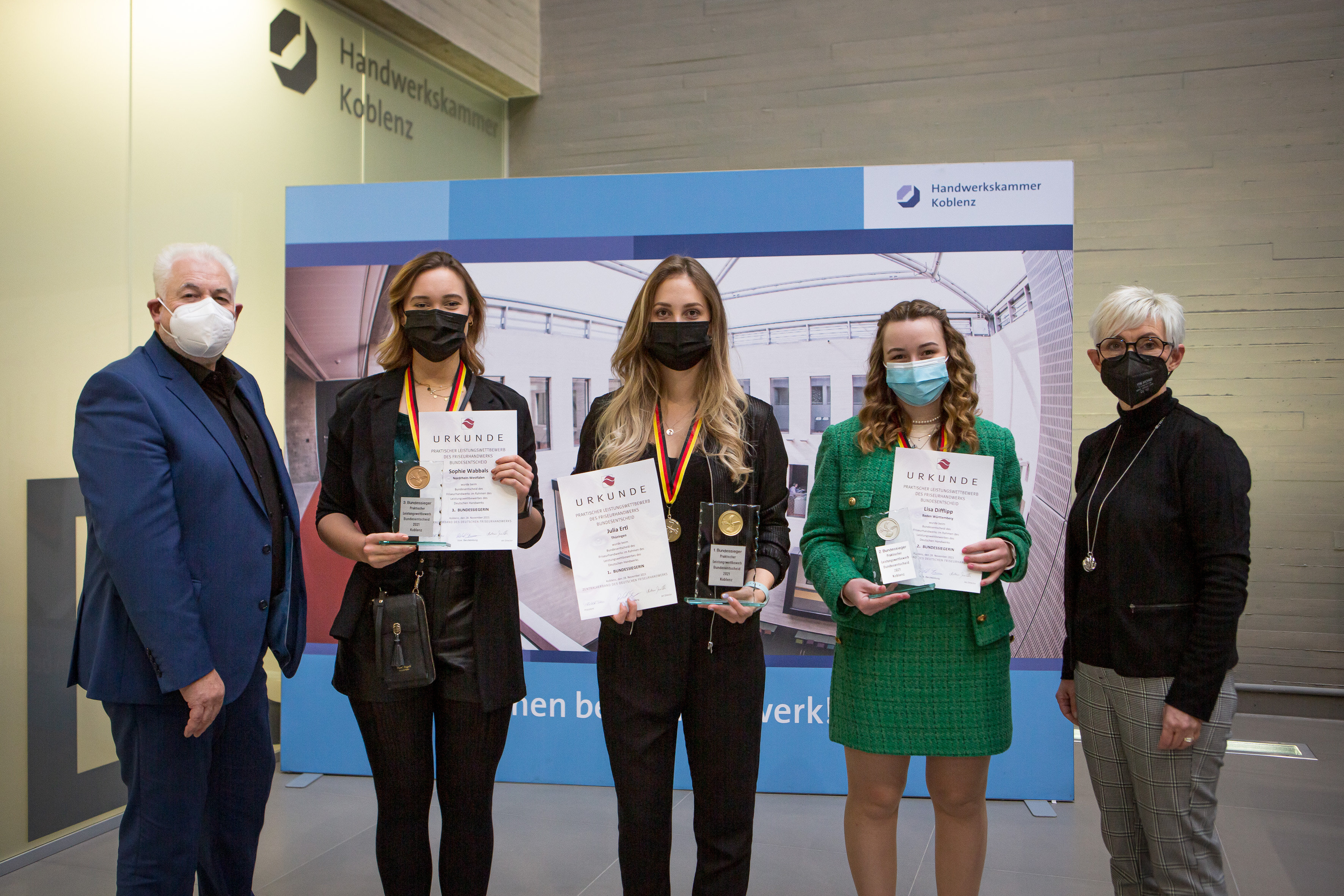 Robert Fuhs (l.) und Manuela Härtelt-Dören (r.) vom Zentralverband gratulierten den drei Erstplatzierten Julia Ertl (M.), Lisa Difflipp (2.v.r.) und Sophie Wabbals zu ihrem guten Abschneiden. Foto: © ZV Friseurhandwerk/Bernward Bertram