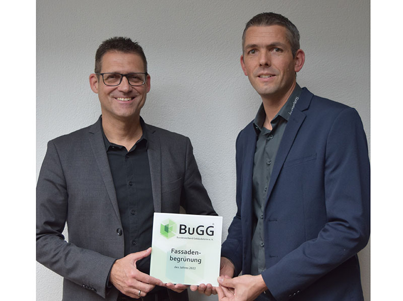 BuGG-Präsident Dr. Gunter Mann (links) überreicht Fabian Meier, Geschäftsführer der Skygardens AG, die Siegerplakette zur BuGG-Fassadenbegrünung des Jahres 2022. Foto: © Bundesverband GebäudeGrün e.V.