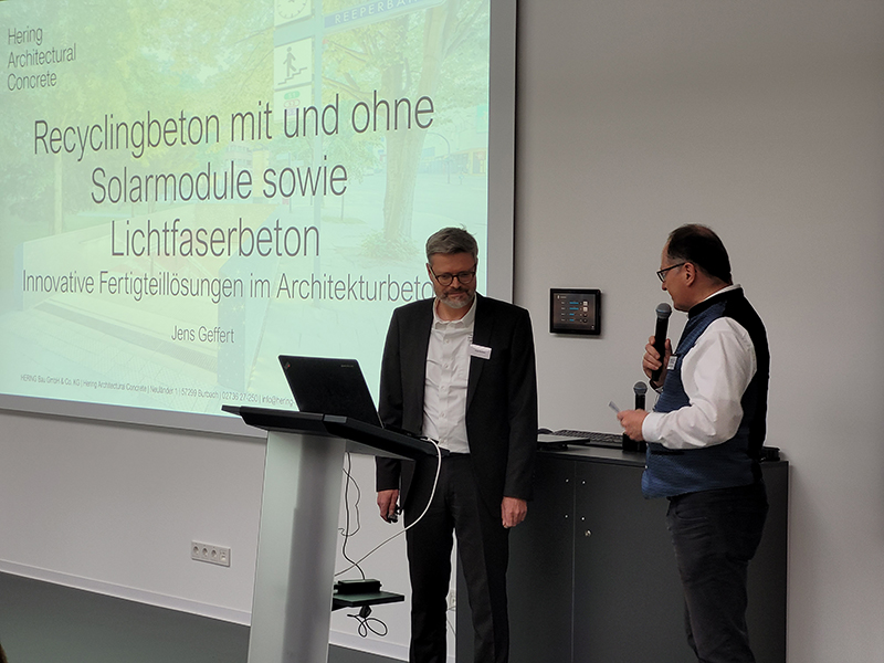 Peter Schermuly übergibt das Mikro an den ersten Referenten Jens Geffert von der gastgebenden Hering Unternehmensgruppe. Foto: © Fachvereinigung Deutscher Betonfertigteilbau