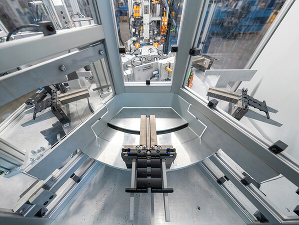 Blick ins Innere der neuen High-Tech-Anlage: Hier ist zu sehen, wie der Automat die Feder aus hochwertigem Federstahl in die mehrgliedrige Kette einschiebt. Foto: © Selve