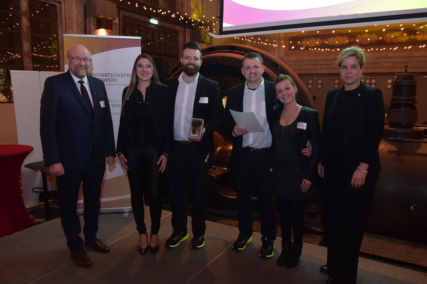 Preisträger in der Kategorie A, Bear-Maschines GmbH aus Heek mit WHKT-Präsident Berthold Schröder (l.) und Wirtschaftsministerin Mona Neubaur (r.). Foto: © WHKT/RG