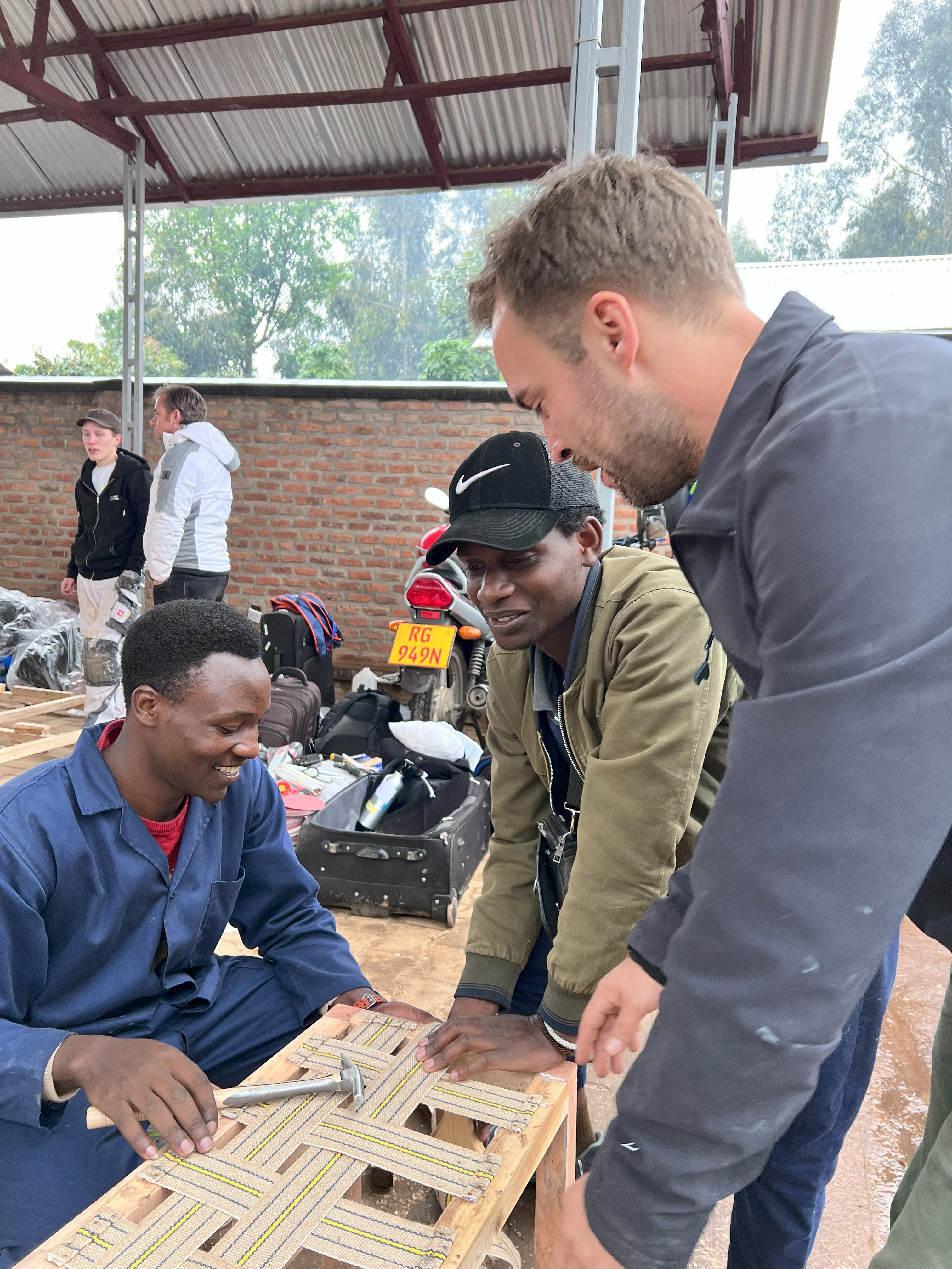 Raumausstatter Joscha Eggert mit ruandischen Berufsschülern bei der Herstellung von Sitzbänken für das Kinder- und Jugendzentrum. Foto: © Verlagsanstalt Handwerk/ Felicitas Winkels