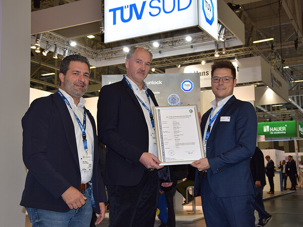 Certificate presentation at the interlift (from left to right): Marc Bayer and Patrick Müller (both elevatec) with Jonas Conrady from TÜV SÜD Industrie Service. Photo: © LIFTjournal / Bernd Lorenz