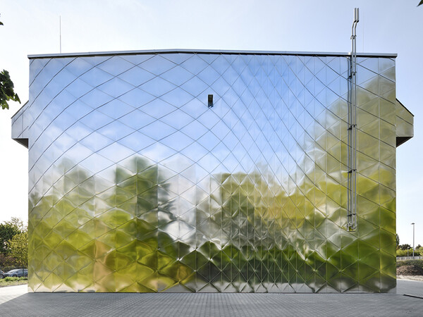 Zehn unterschiedlich dimensionierte Aluminium-Dreiecke sind so angeordnet, dass sich die Verläufe der Schindeln als Wirbel auf der Fassade abbilden. Foto: © Ralf Dieter Bischoff