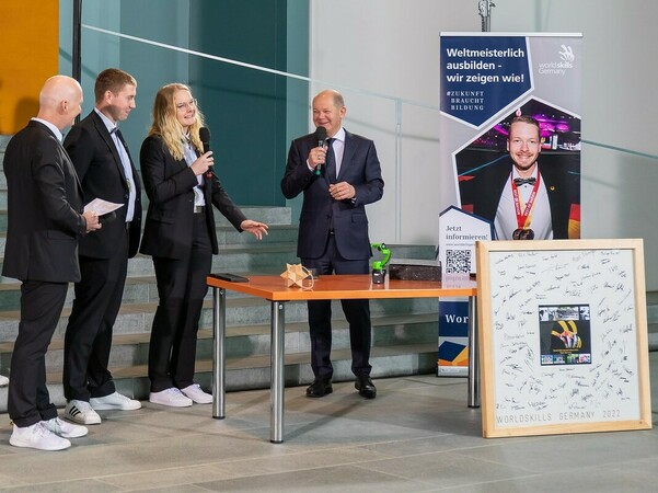 Das Betonbauer-Duo Jule Janson und Jonas Hopf (2.v.l.) im Gespräch mit Bundeskanzler Olaf Scholz. Hubert Romer, Geschäftsführer von WorldSkills Germany (l.), hört interessiert zu. Foto: © WorldSkills Germany/Frank Erpinar Das Betonbauer-Duo Jule Janson und Jonas Hopf (2.v.l.) im Gespräch mit Bundeskanzler Olaf Scholz. Hubert Romer, Geschäftsführer von WorldSkills Germany (l.), hört interessiert zu. Foto: © WorldSkills Germany/Frank Erpinar